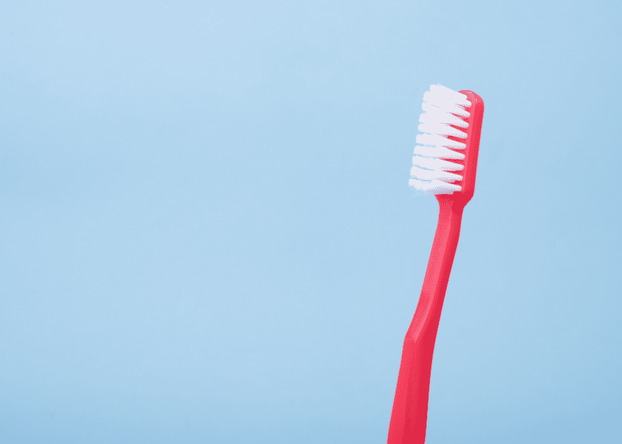 a red toothbrush against a blue backdrop