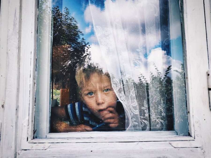 bored kid looking out of a window