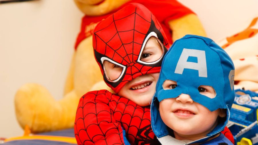 two children wearing super hero costumes 