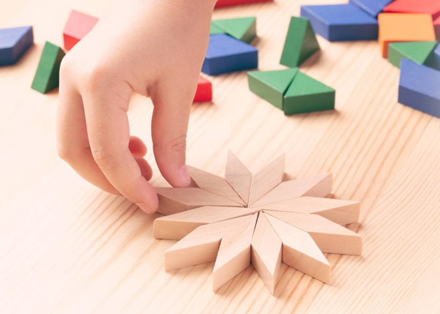 a child playing with colourful wooden blocks