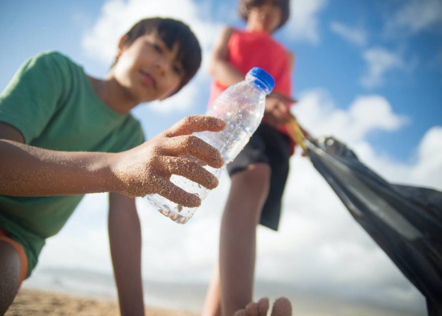 boys picking plastic waste from beach